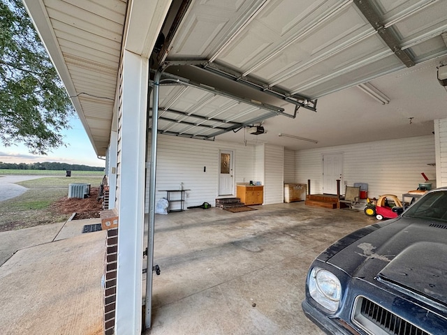 garage featuring central AC, a garage door opener, and a rural view