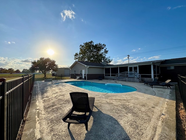 view of swimming pool with a sunroom and a patio area