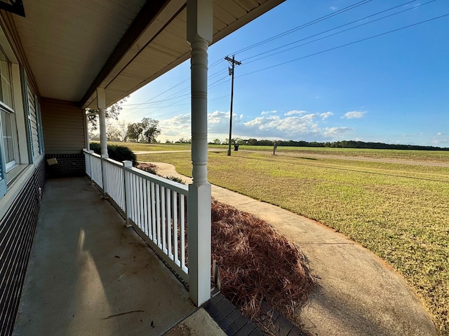 view of yard featuring covered porch and a rural view