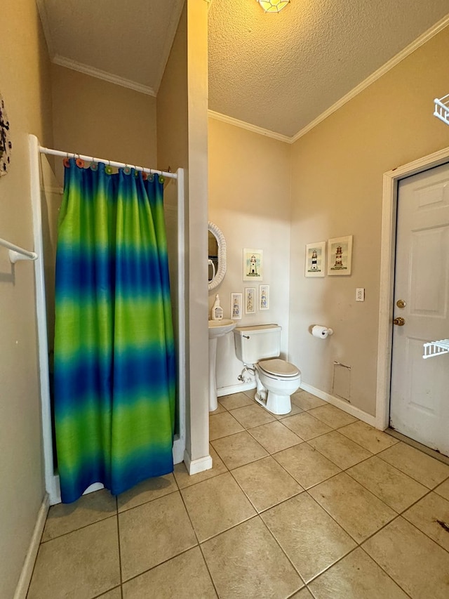 bathroom with tile patterned floors, toilet, ornamental molding, and a textured ceiling