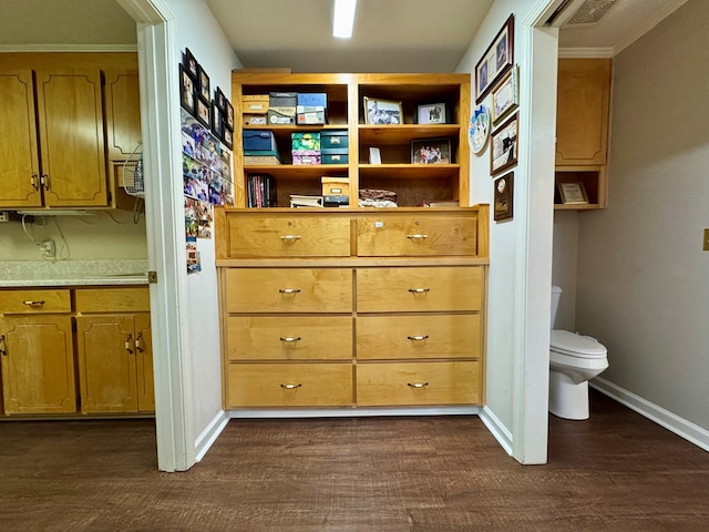 interior space with wood-type flooring, toilet, and ornamental molding