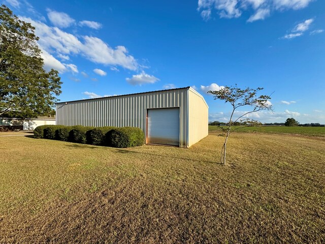 view of outdoor structure featuring a lawn and a garage