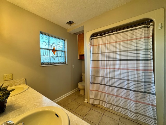 bathroom featuring tile patterned flooring, vanity, a textured ceiling, and toilet