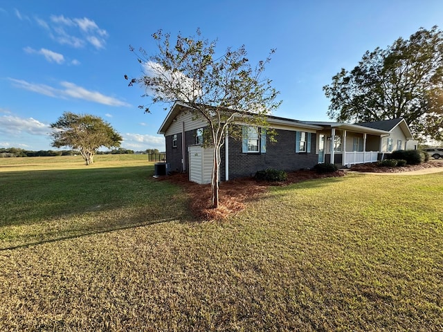 single story home with a porch, central AC unit, and a front lawn