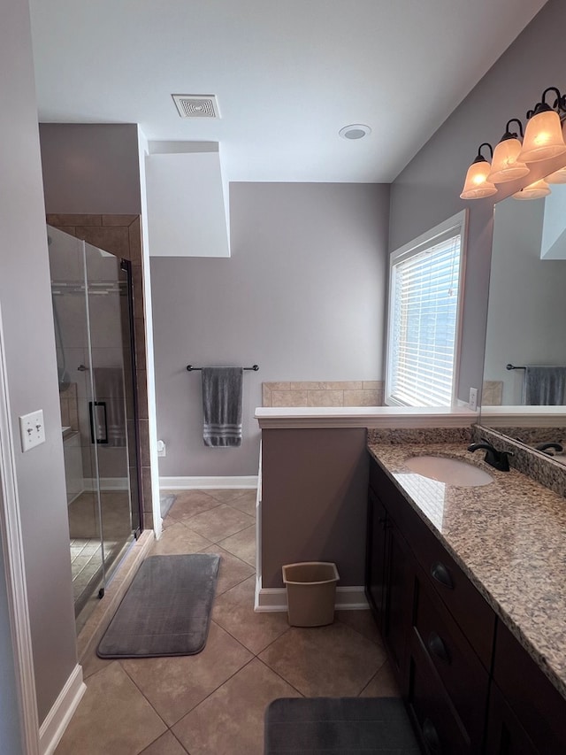 bathroom featuring tile patterned flooring, vanity, and walk in shower