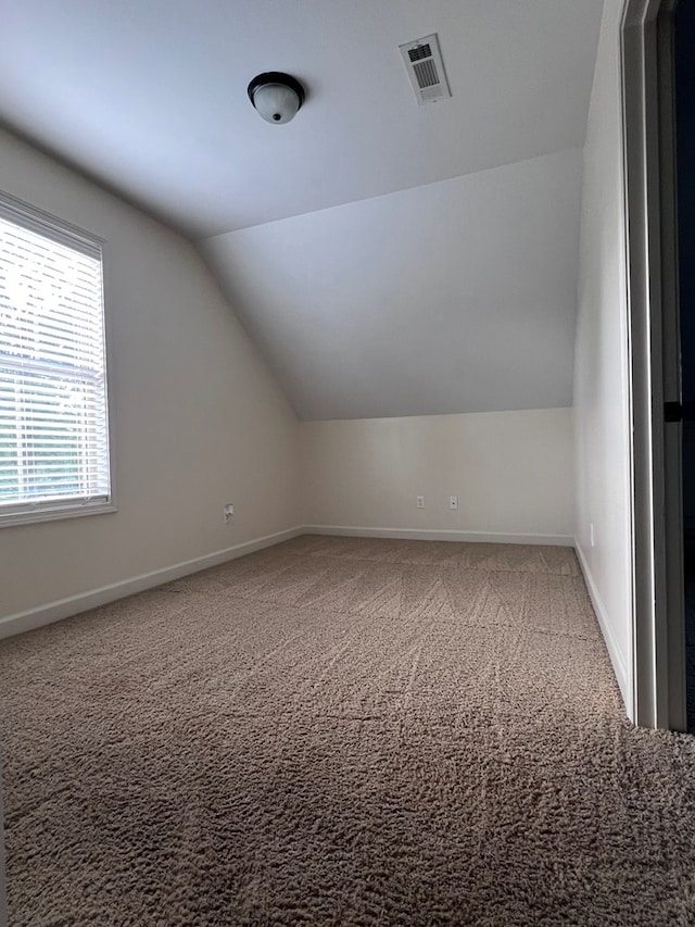 bonus room featuring carpet floors and vaulted ceiling