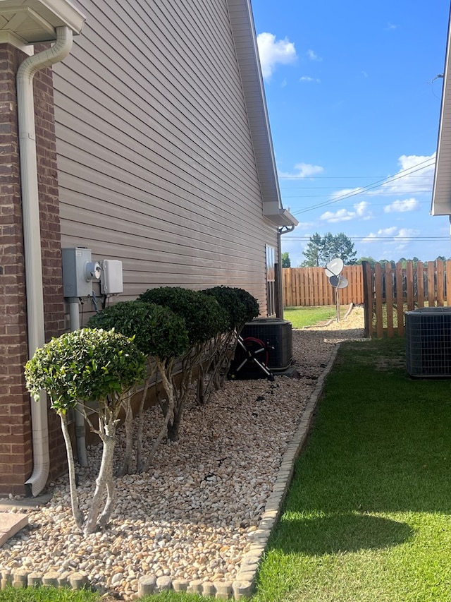 view of home's exterior with central AC unit and a yard