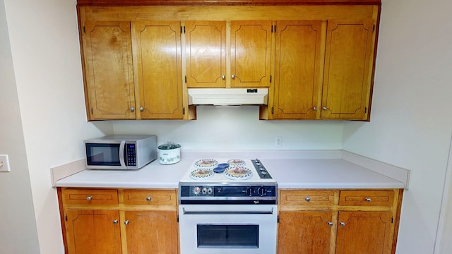 kitchen featuring range with electric cooktop, under cabinet range hood, light countertops, and stainless steel microwave