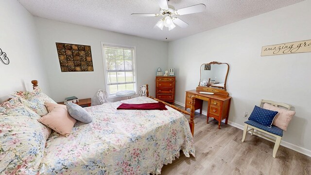 bedroom featuring a textured ceiling, ceiling fan, light wood-type flooring, and baseboards