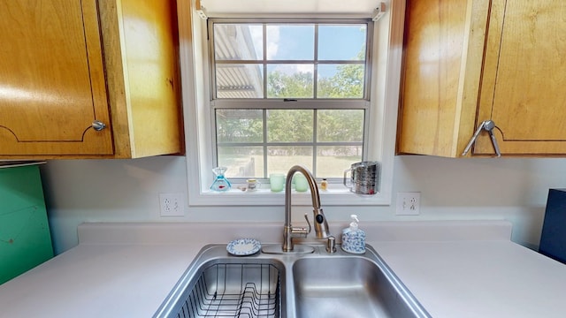 kitchen with brown cabinets, light countertops, and a sink