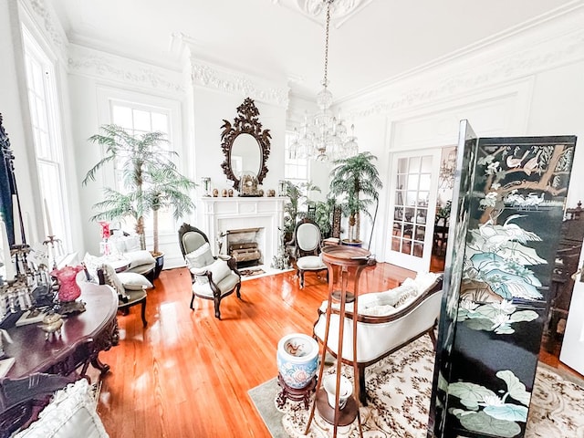 298 E Broad St, Ozark, AL 36360 - living area featuring healthy amount of natural light, a fireplace with flush hearth, wood finished floors, crown molding, and a chandelier