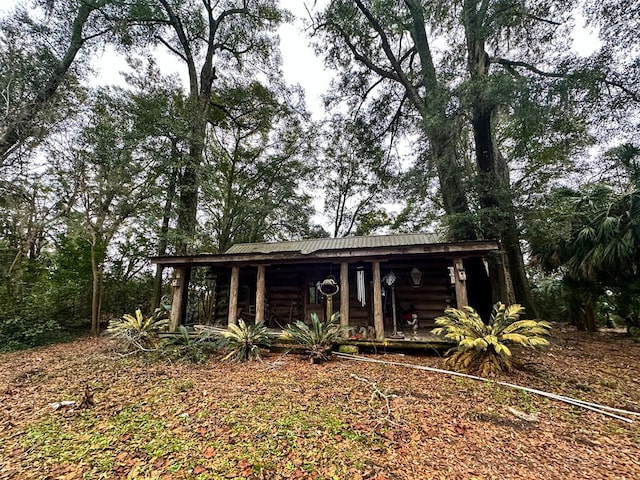 298 E Broad St, Ozark, AL 36360 - log cabin featuring a porch, metal roof, and log siding