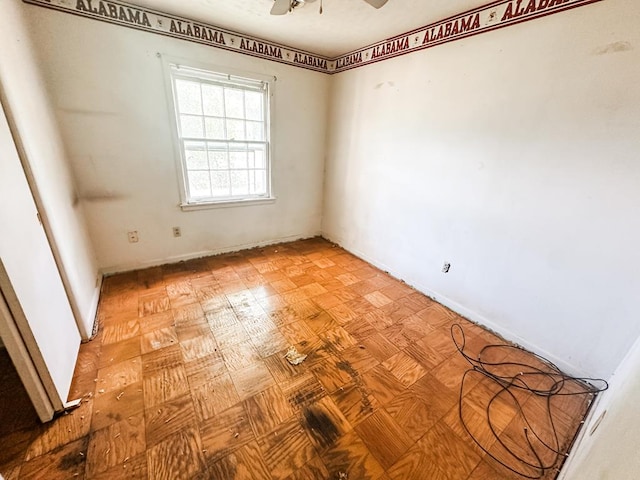 spare room with baseboards and a ceiling fan