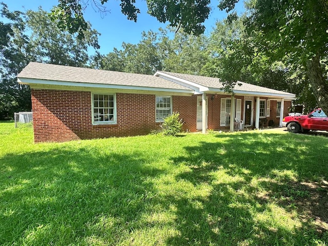 ranch-style home featuring a front yard and brick siding