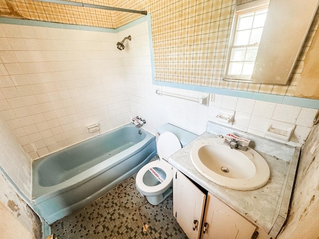 full bathroom featuring toilet, vanity,  shower combination, and tile walls