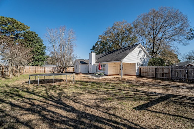 view of yard featuring a trampoline and a patio