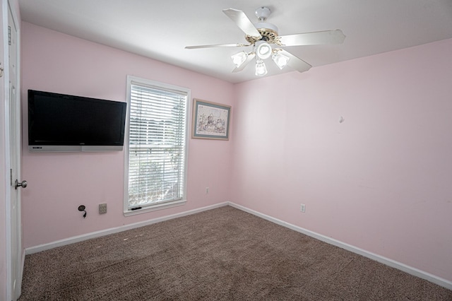 unfurnished room with ceiling fan and carpet