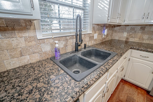 kitchen with dark hardwood / wood-style flooring, decorative backsplash, white cabinets, and sink