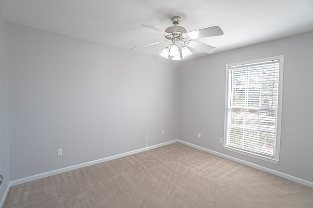 carpeted spare room featuring ceiling fan