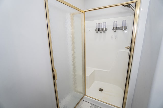 bathroom featuring a shower with door