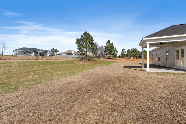 view of yard featuring ceiling fan and a patio