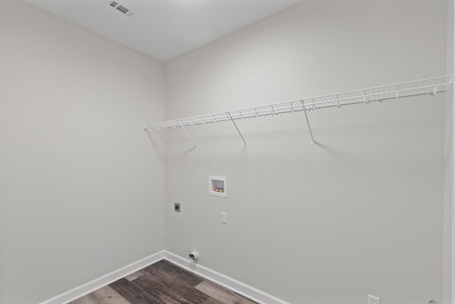 clothes washing area with electric dryer hookup, washer hookup, and hardwood / wood-style flooring