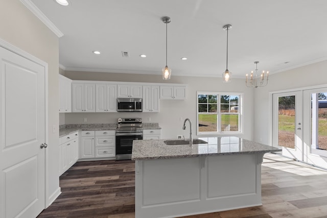 kitchen featuring sink, stainless steel appliances, light stone counters, an island with sink, and white cabinets