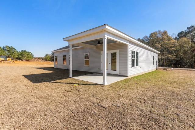 back of property with ceiling fan, a patio area, and a lawn