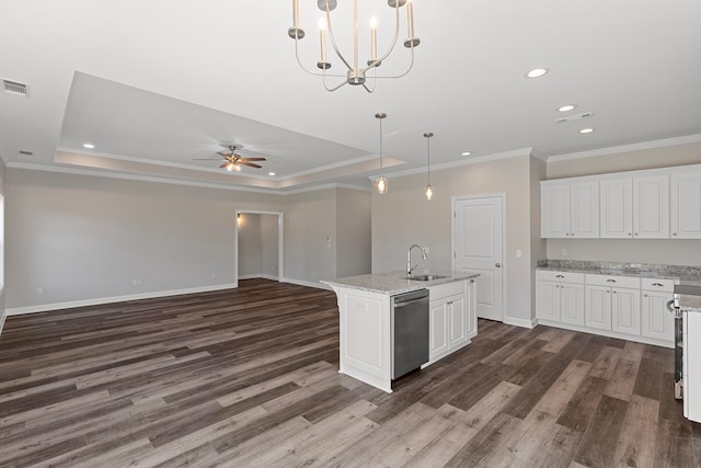 kitchen with stainless steel dishwasher, a kitchen island with sink, hanging light fixtures, and a tray ceiling