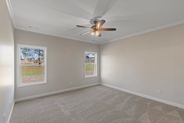 carpeted empty room with a wealth of natural light, ornamental molding, and ceiling fan