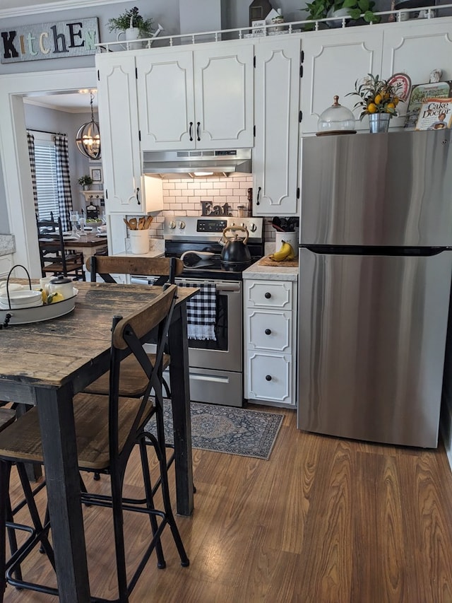 kitchen with white cabinetry, dark hardwood / wood-style flooring, decorative light fixtures, decorative backsplash, and appliances with stainless steel finishes