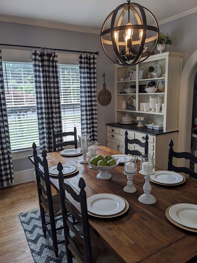 dining area featuring a chandelier, light wood-type flooring, a wealth of natural light, and crown molding