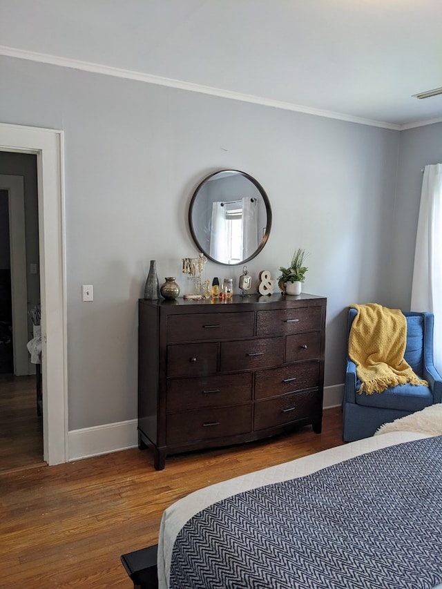 bedroom featuring hardwood / wood-style flooring and crown molding