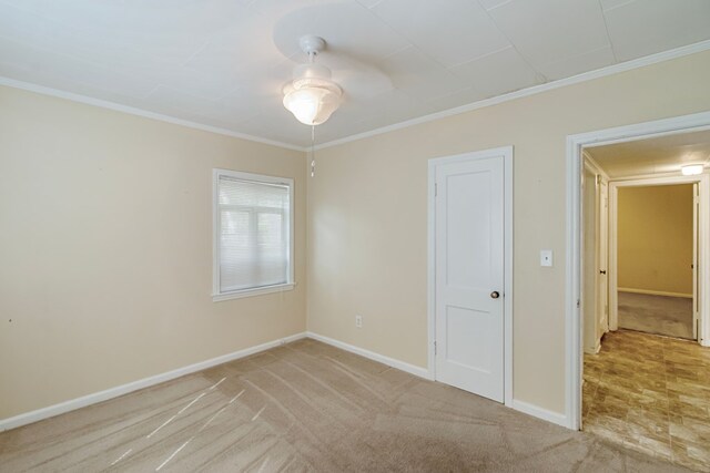 carpeted empty room featuring ceiling fan and ornamental molding