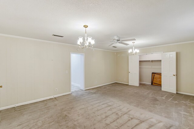 carpeted empty room with ceiling fan with notable chandelier and ornamental molding