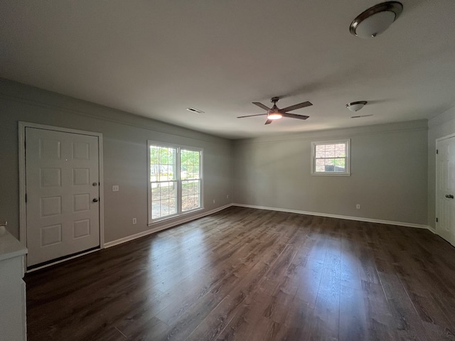 spare room featuring dark hardwood / wood-style flooring, a wealth of natural light, and ceiling fan