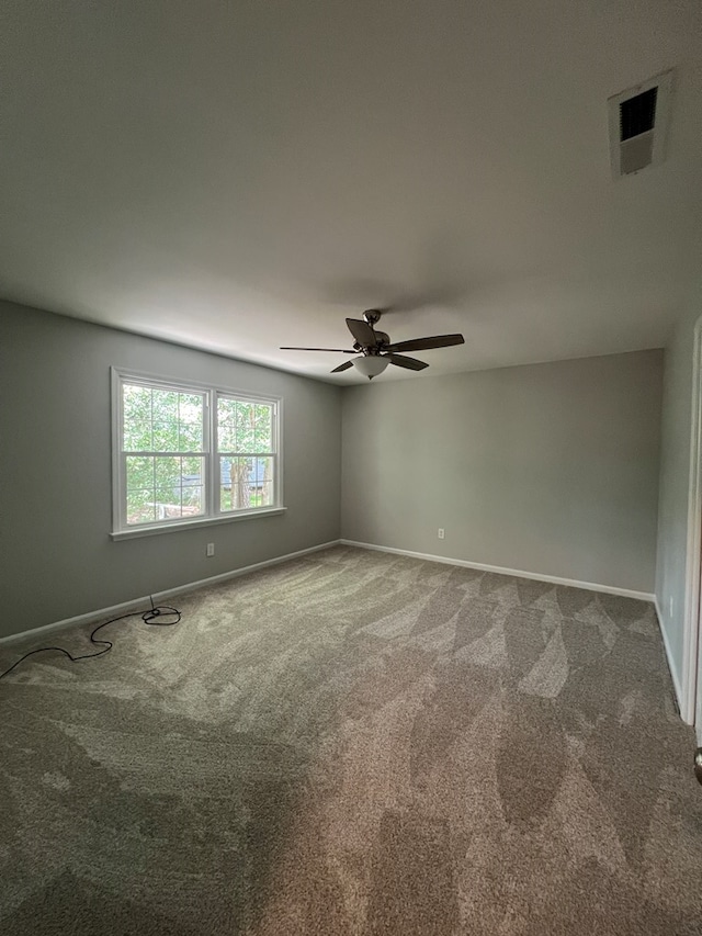 carpeted spare room with ceiling fan