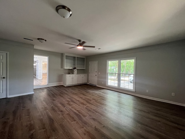 unfurnished living room with ceiling fan and dark wood-type flooring