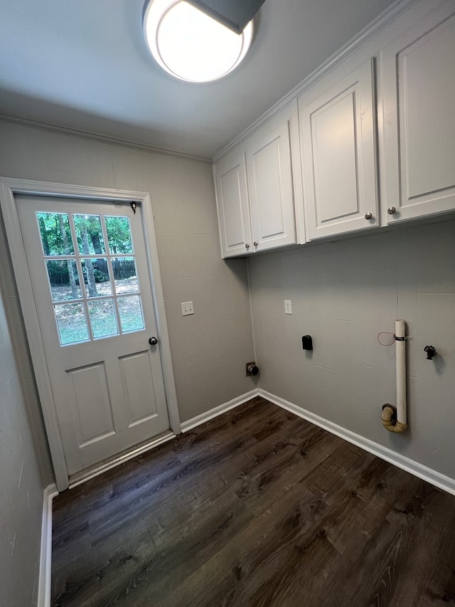 laundry area featuring cabinets, dark hardwood / wood-style flooring, and ornamental molding