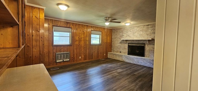1109 Sumter St, Dothan, AL 36301 - unfurnished living room featuring ceiling fan, a brick fireplace, heating unit, dark wood-style flooring, and crown molding