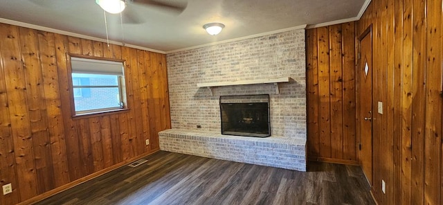 1109 Sumter St, Dothan, AL 36301 - unfurnished living room featuring crown molding, a ceiling fan, wood finished floors, a fireplace, and wooden walls