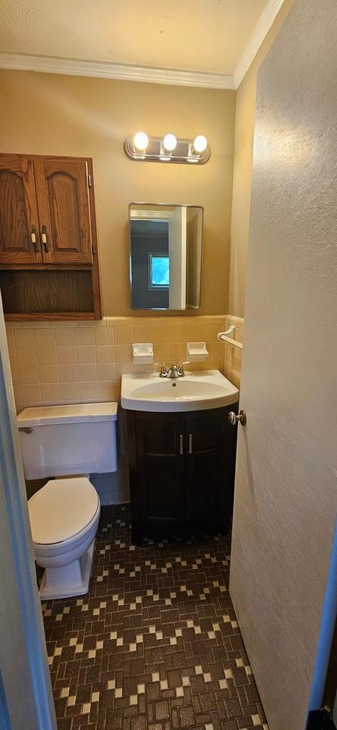 1109 Sumter St, Dothan, AL 36301 - half bath featuring ornamental molding, vanity, and tile walls