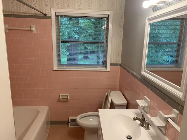 1109 Sumter St, Dothan, AL 36301 - full bath with wallpapered walls, tile walls, wainscoting, a tub to relax in, and vanity
