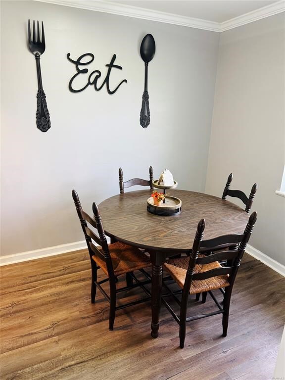 dining room with baseboards, crown molding, and wood finished floors