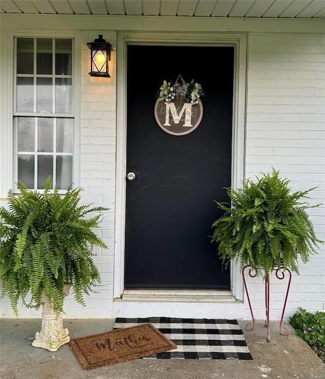doorway to property with brick siding