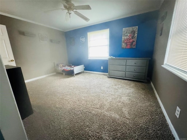 unfurnished bedroom featuring carpet, a ceiling fan, crown molding, and baseboards