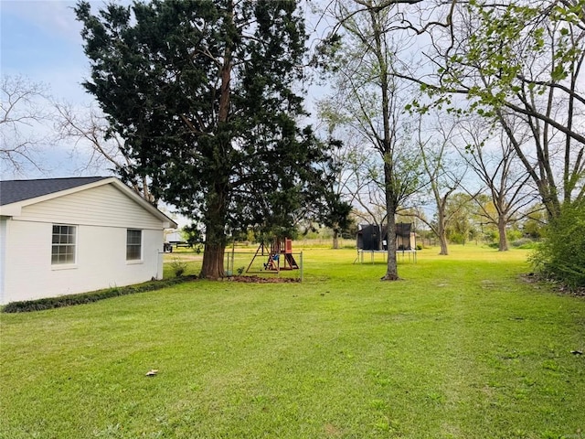 view of yard featuring a trampoline and a playground