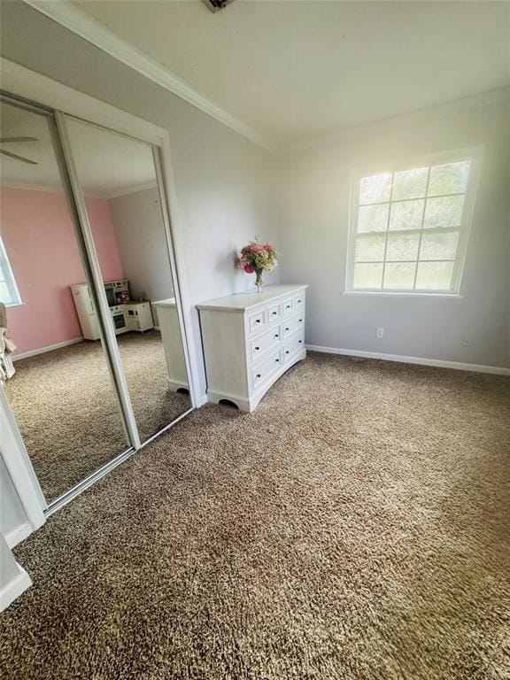 unfurnished bedroom featuring baseboards, ornamental molding, and carpet