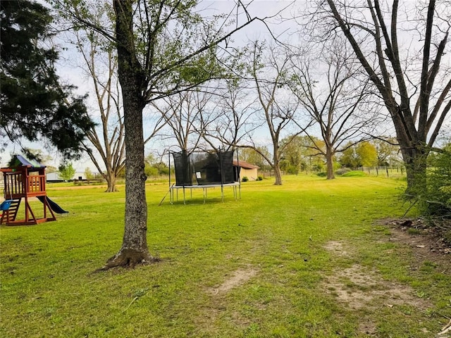 view of yard featuring a playground and a trampoline