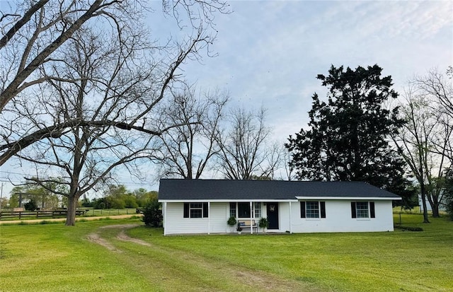 view of front of home featuring a front lawn, driveway, and fence